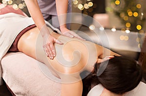 Woman lying and having back massage at spa parlor