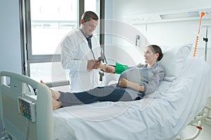 Woman lying on hospital bed in ward