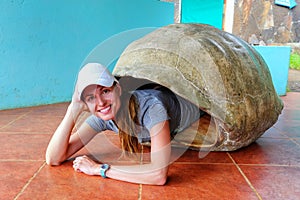 Woman lying inside empty Galapagos giant tortoise shell at the s