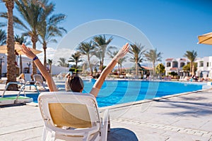 Woman lying on a lounger by the pool