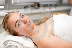 Woman lying on massage table prepaired for beauty treatment.