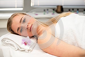 Woman lying on massage table prepaired for beauty treatment.