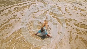 Woman lying on shallow water sea. Happy slightly tipsy woman enj