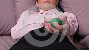 Woman lying and squeezing stress ball