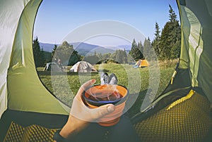 Woman lying in a tent with coffee