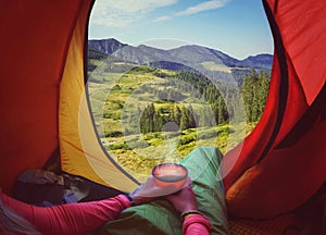 Woman lying in a tent with coffee