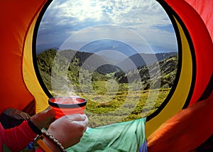 Woman lying in a tent with coffee