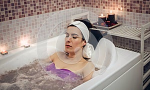 Woman lying in tub doing hydrotherapy treatment photo