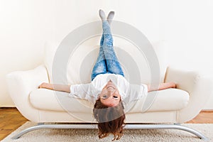 Woman lying upside down on a sofa