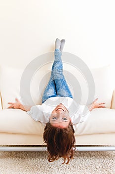 Woman lying upside down on a sofa