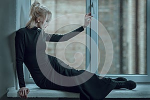 Woman lying on the window sill and sad.