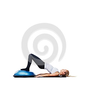 Woman, lying and workout on bosu ball for exercise, training or abs on a white studio background. Active female person