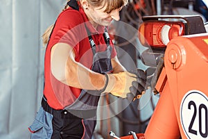 Woman machinist working with wrench of a farm machine