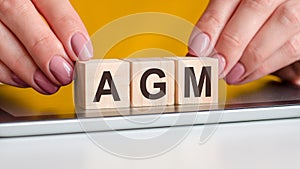 woman made word AGM with wooden blocks, concept