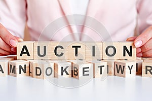 Woman made word Auction with wooden blocks and many blocks with letters