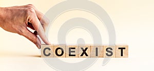 Woman made word COEXIST with wood blocks
