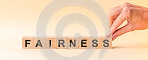 Woman made word fairness with wooden blocks, concept photo