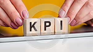 Woman made word kpi with wooden blocks, business concept