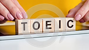 Woman made word toeic with wooden blocks, concept