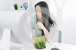 Woman with magnifier glass examining a desktop computer .Scanning Files Searching Processing Anti-virus Concept