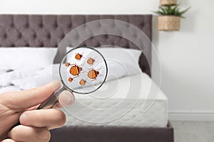 Woman with magnifying glass detecting bed bugs on mattress, closeup. photo