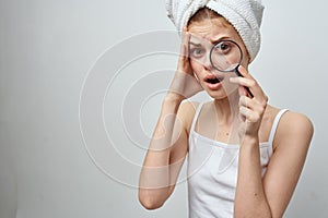 woman with a magnifying glass in hand skin problems close-up
