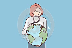 Woman with magnifying glass holds globe studying geography or choosing place for further travel
