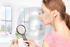 Woman with magnifying glass and money