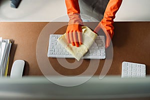 Woman maid cleaning and wiping the table with microfiber cloth in office