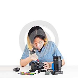 Woman maintenance a DSLR Camera with dust brower in her hand