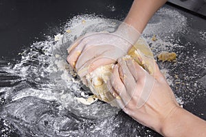 Woman make dough for bakery on black surface