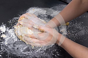 Woman make dough for bread. fresh dough on black kitchen