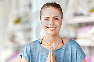 Woman make namaste gesture at yoga studio