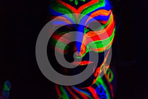 Woman with make up art of glowing UV fluorescent powder