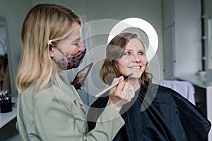 Woman make-up artist work in her studio with model