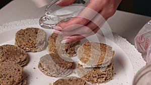 A woman makes a biscuit cake. Applies liquid impregnation to workpieces. With a brush. Close-up
