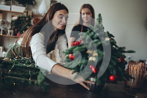 A woman makes a Christmas tree with her own hands.