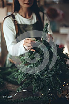A woman makes a Christmas tree with her own hands.