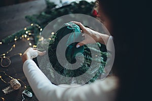 A woman makes a Christmas tree with her own hands.