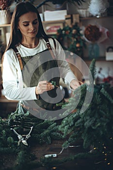 A woman makes a Christmas tree with her own hands.