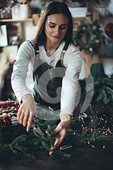 A woman makes a Christmas tree with her own hands.