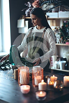 A woman makes a Christmas tree with her own hands.