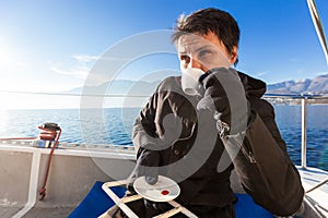 Woman makes a coffee break on the sail boat