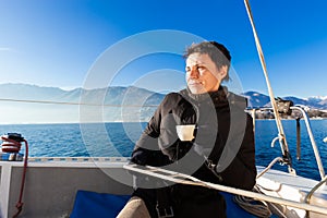 Woman makes a coffee break on the sail boat