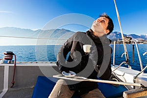 Woman makes a coffee break on the sail boat