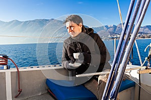 Woman makes a coffee break on the sail boat