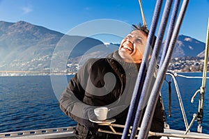 Woman makes a coffee break on the sail boat