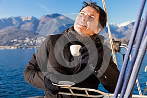 Woman makes a coffee break on the sail boat