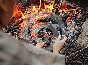 Woman makes a coffee on campfire