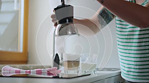 Woman makes coffee latte in geyser coffee maker at home